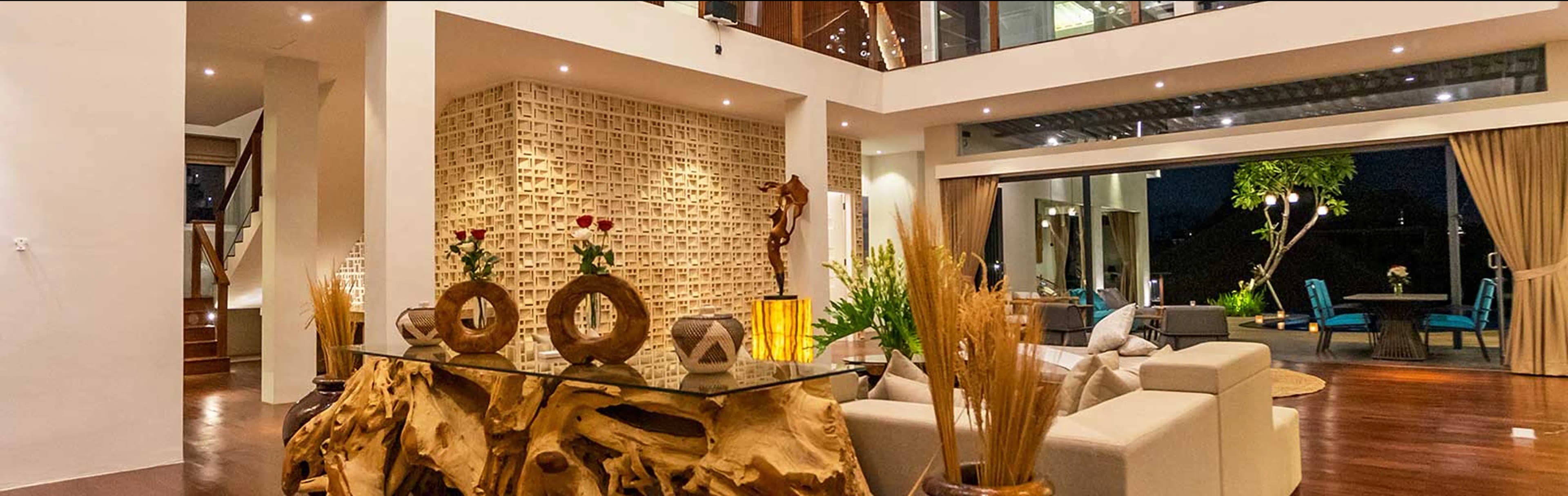 Stylish open-concept dining area in a Bali villa featuring natural wood furniture, modern pendant lighting, and tropical indoor plants.