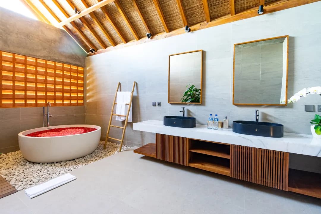 Spacious bathroom in bedroom three at Jiwoku Villas Canggu Bali with flower-filled bathtub, double vanity, and natural lighting
