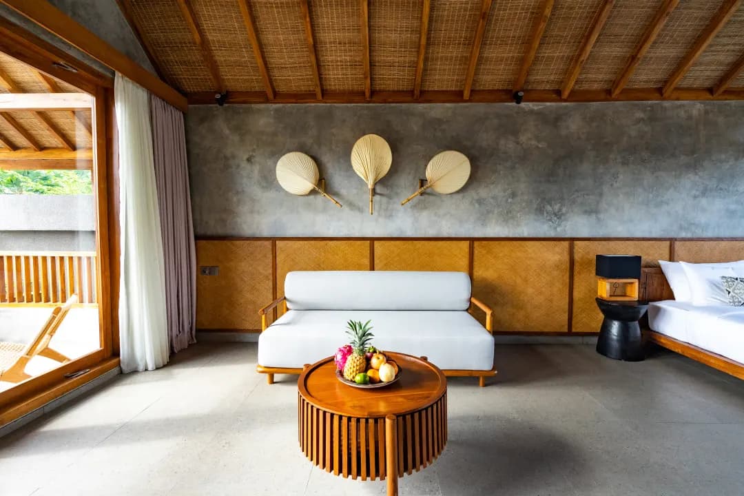Sofa lounge area in bedroom three at Jiwoku Villas Canggu Bali with balcony access and tropical light