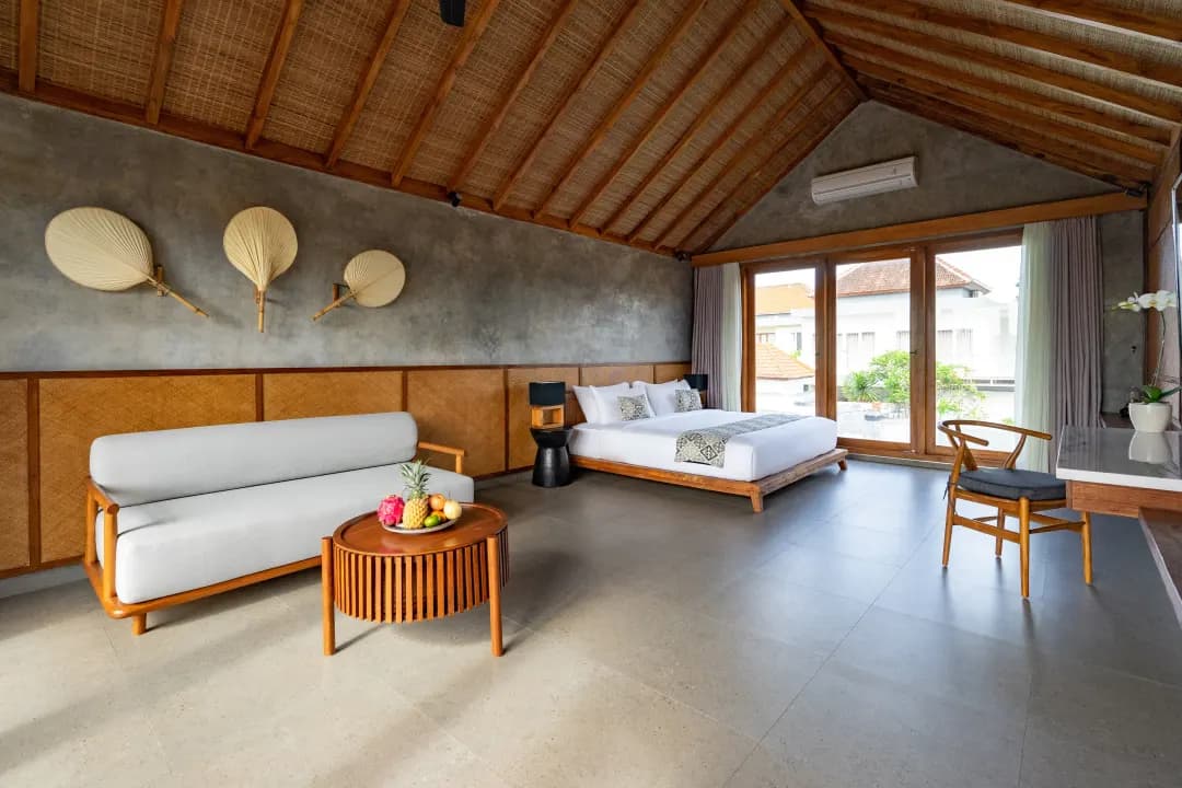 Bedroom three at Jiwoku Villas Canggu Bali with twin single beds, sofa, and tropical rooftop view